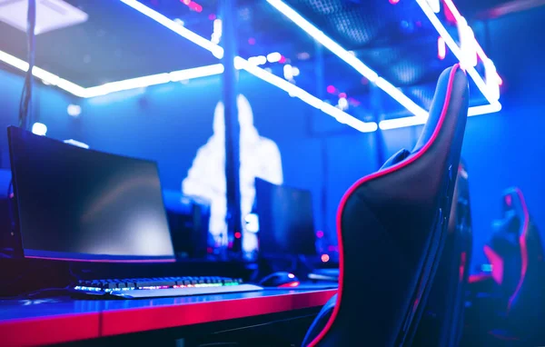 Computador de fundo desfocado pc, poltrona de teclado, luzes azuis e vermelhas. Conceito online arena eSports para jogadores que jogam torneios — Fotografia de Stock