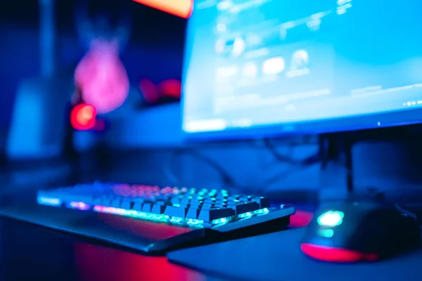 Niewyraźny komputer tła, klawiatura, niebieskie i czerwone światła. Koncepcja esports arena dla graczy turniejów gry — Zdjęcie stockowe