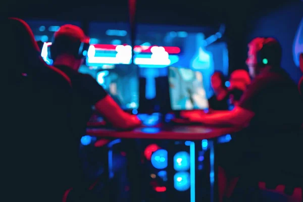 Equipo profesional de fondo borroso grupo de jugadores jugando torneos juegos en línea ordenador con auriculares, rojo y azul — Foto de Stock