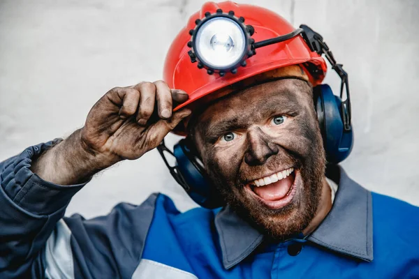 Retrato minero masculino feliz después de trabajar en la mina de carbón, la cara sucia en el casco — Foto de Stock