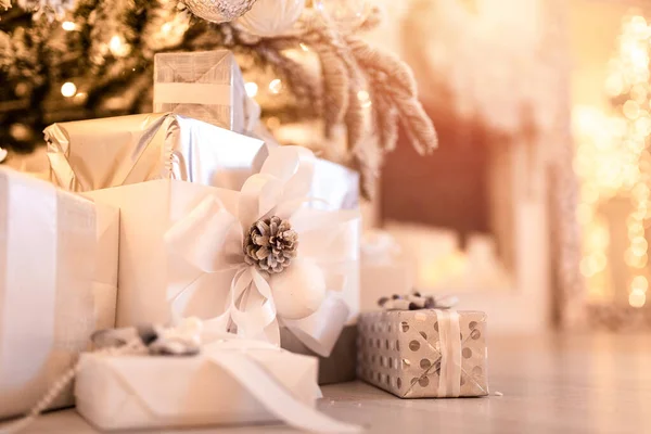 Χριστουγεννιάτικα δώρα κουτί κάτω από το δέντρο με τεχνητό χιόνι με χρυσό φωτισμό. Χρώμα ασημί — Φωτογραφία Αρχείου