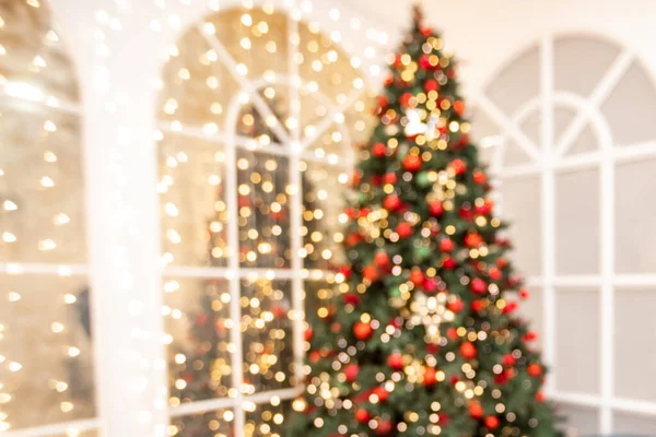 Wazig achtergrond Kerst kamer interieur met nieuwjaarsboom en geschenken verlichting in rode, groene kleuren — Stockfoto