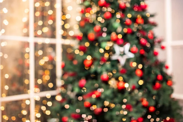 Розмитий фон Різдвяний інтер'єр з новорічною ялинкою та подарунками в червоному, зеленому кольорах — стокове фото