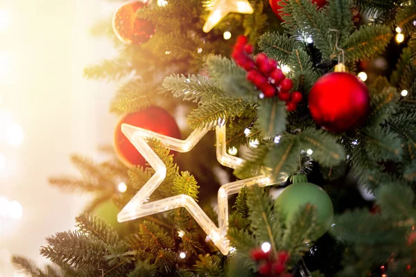 Kerstachtergrond dennenboom tak met decoraties rode ballen geschenken en ster, met bokeh licht — Stockfoto