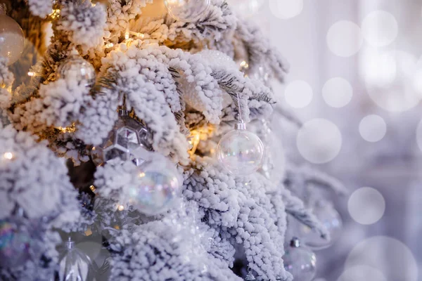 Árbol blanco navideño decorado con iluminación de nieve y juguetes de regalos, luz de fondo bokeh, color plata —  Fotos de Stock