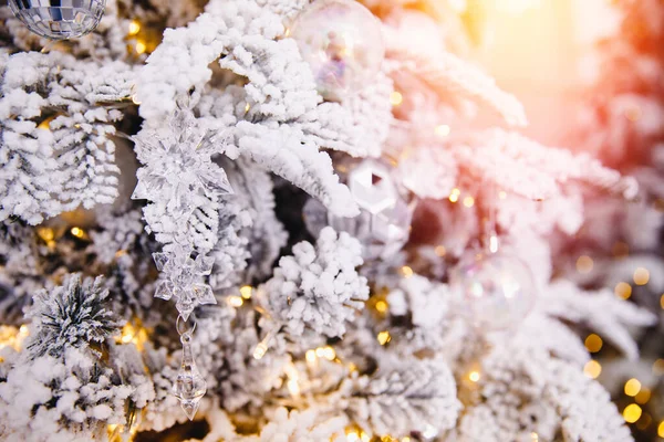 Albero di Natale sfondo con neve artificiale decorato giocattoli palle, ramo illuminazione dorata — Foto Stock