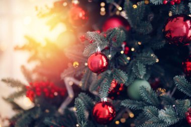 Noel ağacı süslemeleri olan yeni yıl ağacı. Kırmızı toplar, hediyeler ve ışık saçan bir yıldız.
