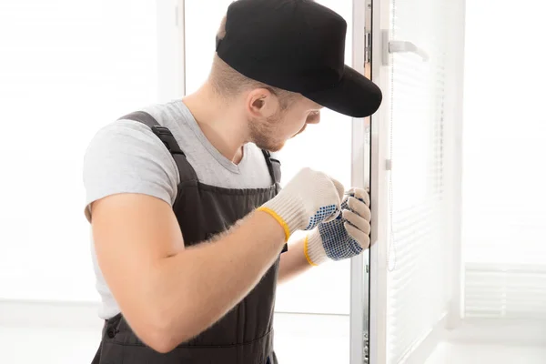 Trabalhador da construção homem instalar plástico branco upvc janelas na casa — Fotografia de Stock