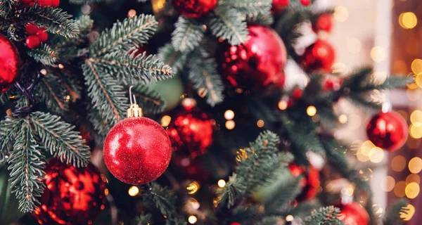 Rama de pino de fondo de Navidad con decoraciones bolas rojas regalos y estrellas, con luz bokeh —  Fotos de Stock