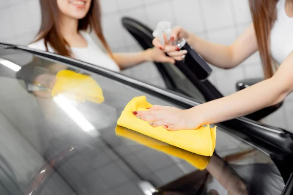 Hermosas mujeres trabajadoras lavando parabrisas con esponja en el coche, ventana limpia spray —  Fotos de Stock