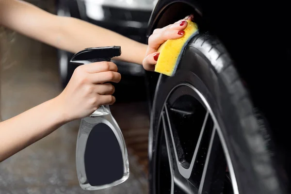 Servicio de lavado de coches, detallando el uso de aerosol y esponja para limpiar el neumático negro —  Fotos de Stock