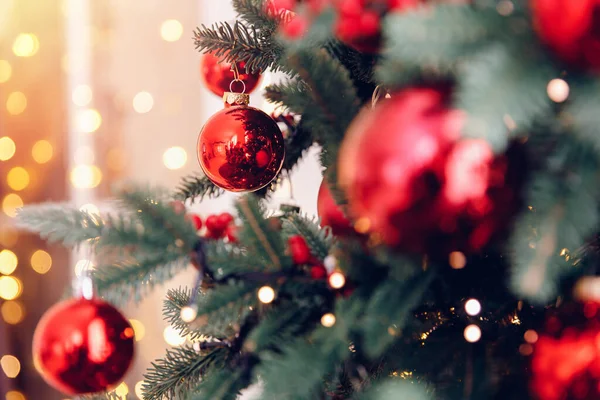 Boże Narodzenie tło drzewo New Yeae oddział z dekoracjami czerwone kulki prezenty i gwiazda, z bokeh światło — Zdjęcie stockowe