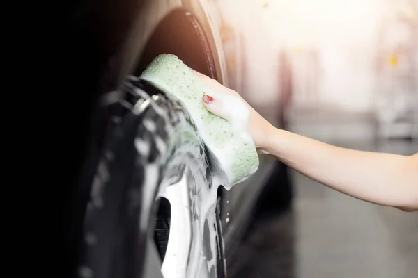 Trabajador de mano coche lavar neumático de rueda negro y caucho con esponja —  Fotos de Stock