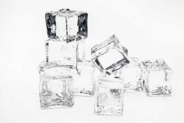 Buz küpleri kare beyaz zemin üzerinde temiz su damlaları ile