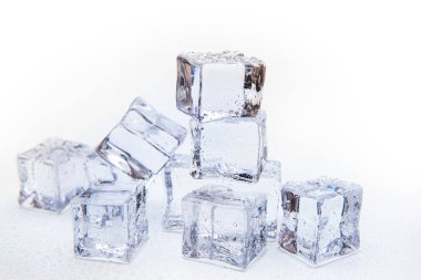 Buz küpleri kare beyaz zemin üzerinde temiz su damlaları ile