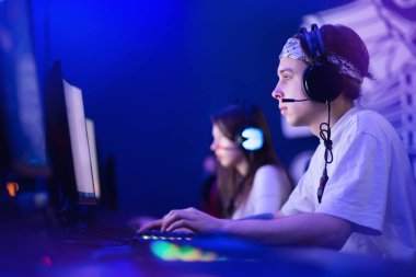 Profesyonel takım oyuncusu turnuva oynuyor çevrimiçi oyun bilgisayarı kulaklıkla, kırmızı ve mavi