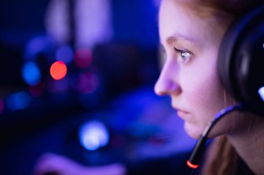 Çağrı merkezi güzel kız operatörü profesyonel oyuncu gülümseyen ve mikrofona konuşan koyu mavi neon arka plan