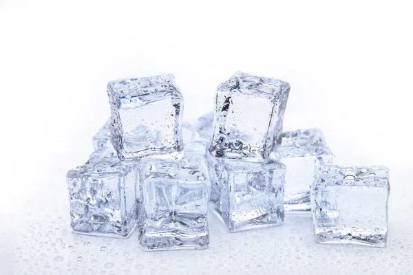 Cubos de hielo cuadrados con gotas de agua limpia sobre fondo blanco — Foto de Stock