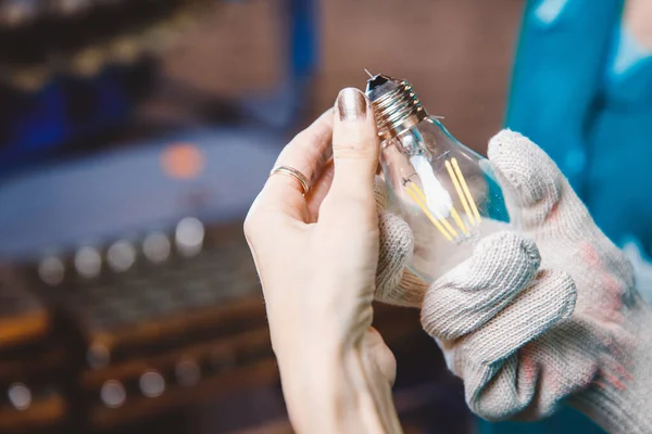 Las manos del trabajador recogen la lámpara de vidrio eléctrica, ponen la tapa en los cables — Foto de Stock