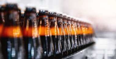 Kahverengi cam bira alkol şişeleri, bira fabrikası taşıyıcısı, üretim hattı.