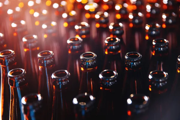 Крупный план открытые коричневые стеклянные темные бутылки для пива спирт, блики линзы — стоковое фото