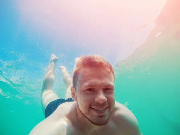 Happy man plonge sous la mer avec caméra d'action, prend des photos selfie. Concept plongée avec tuba — Photo