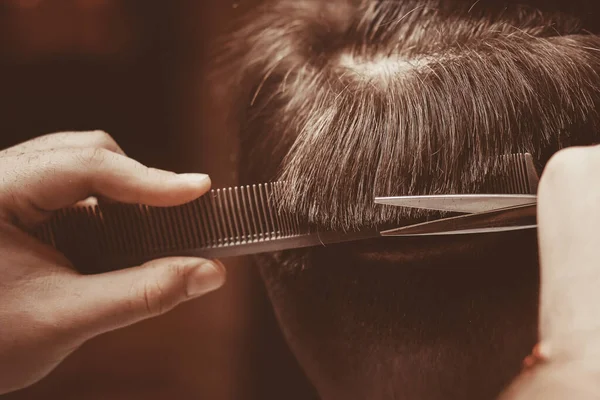 Man haircut, master does hair styling hipster in barber shop