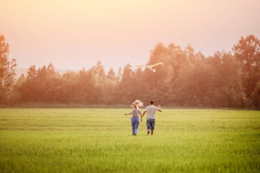 Sevgi dolu çift, yağmurda uçurtma ve dikiz aynasıyla el ele tutuşuyor. Aile kavramı, özgürlük.