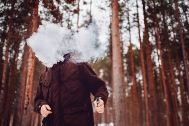 Mod cihazı tutan buharlı adam. Vape bulutu
