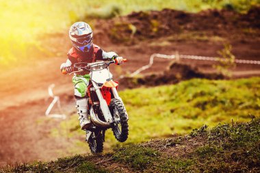 Motosikletli yarışçı çocuk motokrosa katılıyor