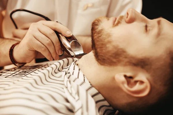 Barber si depila la barba per diventare un hipster in un barbiere. Foto tonica, stile vintage — Foto Stock