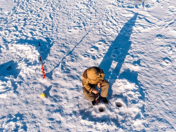 Wędkarstwo zimowe na lodzie, widok z góry, wędka w dołku jeziora — Zdjęcie stockowe