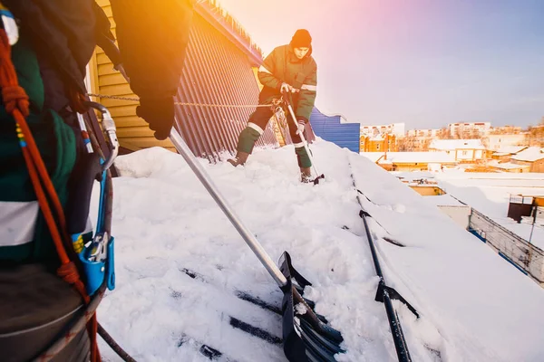 Schneeräumen. Männerteam putzt Dach — Stockfoto