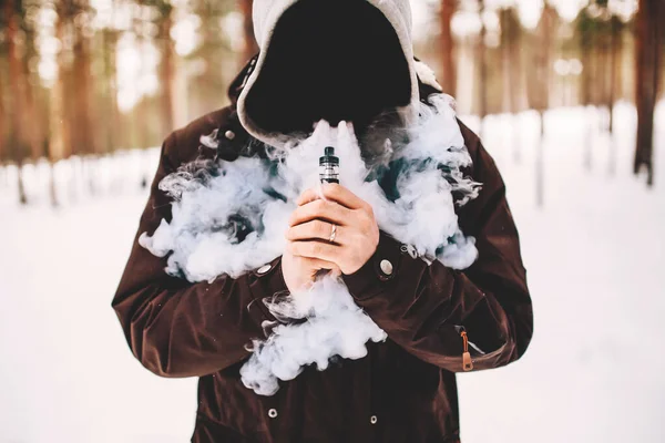 Вейп-людина тримає модний пристрій. хмара пара — стокове фото