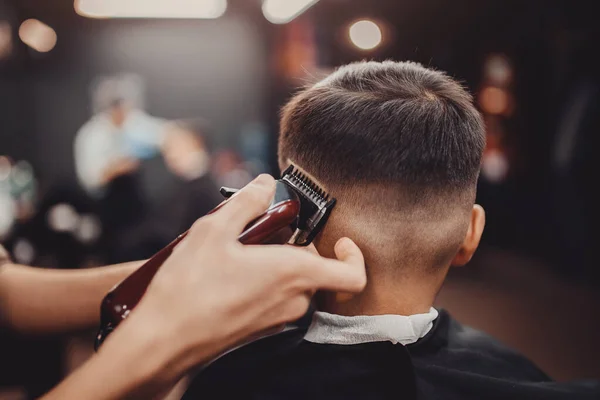 Barbershop Man Barber in men hairdresser does hair with scissors