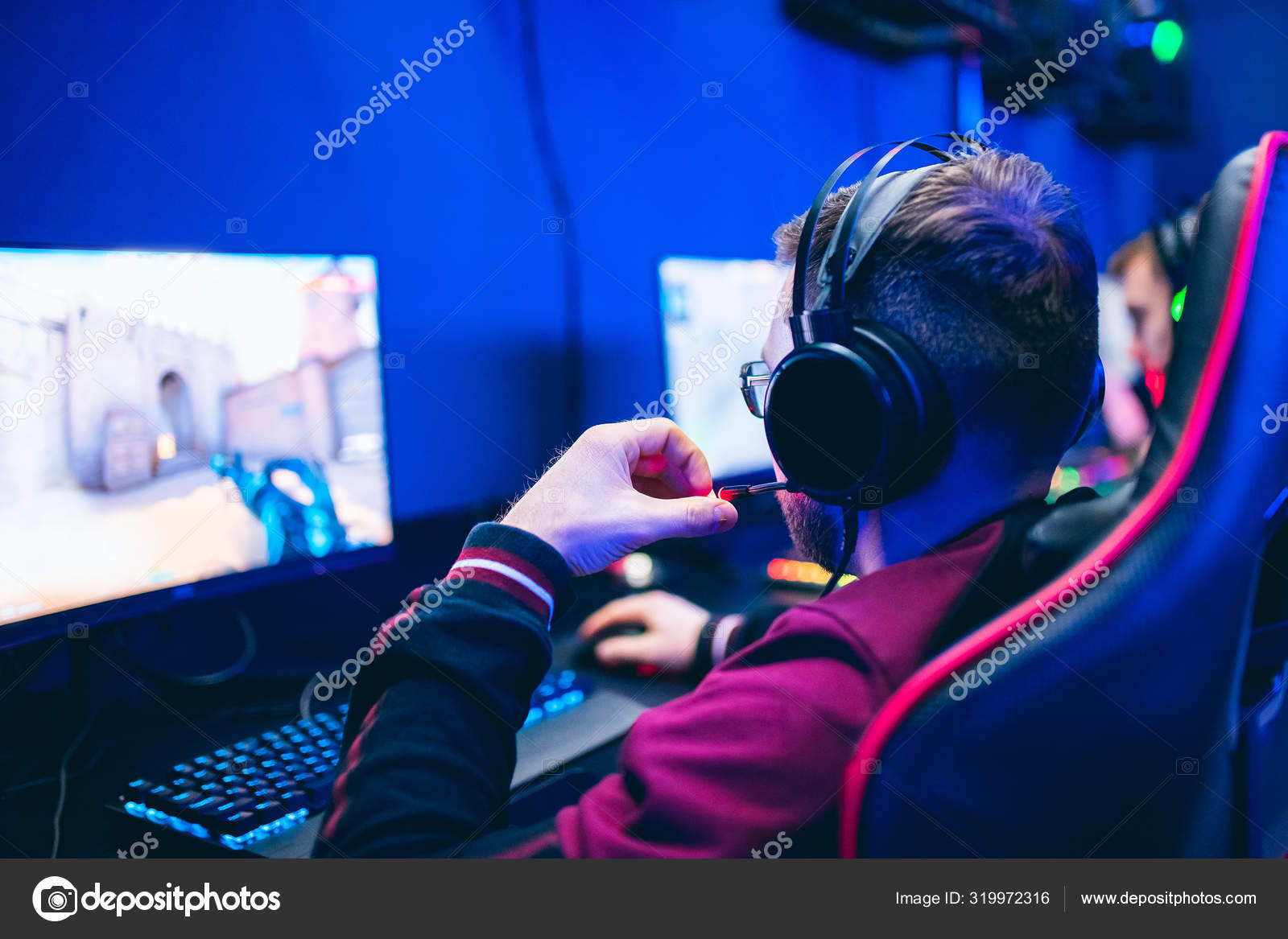 Professional gamer playing online games tournaments pc computer with headphones, Blurred red and blue background Stock Photo by ©ParStud 319972316