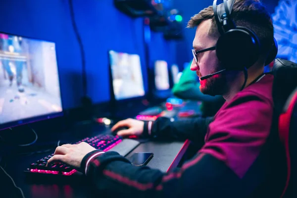 Sala de estudio profesional de videojuegos cibernéticos con sillón de computadora personal, teclado para flujo en fondo borroso de color neón. Enfoque suave —  Fotos de Stock