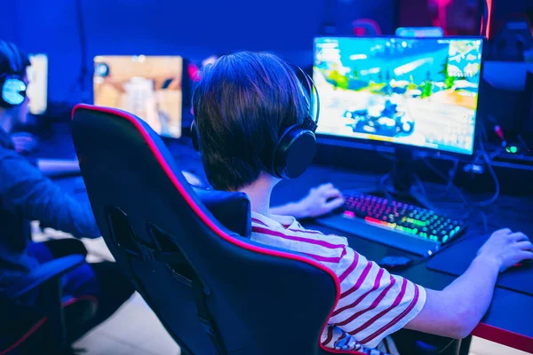 Jugador profesional jugando torneos online videojuegos ordenador con auriculares, rojo y azul — Foto de Stock