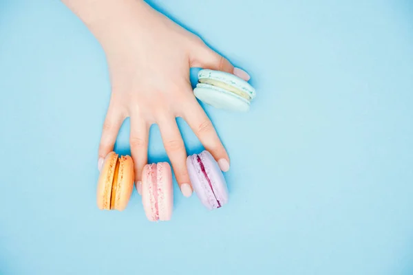 Menina de mão de beleza com unhas de manicure na moda tomando macaroons de cor. Conceito cuidados com a pele, flat lay — Fotografia de Stock