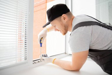 İnşaat işçisi eve plastik beyaz upvc pencereler takıyor
