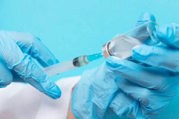 Доктор рука тримає шприц і вакцину в синіх рукавичках біле пальто. Концепція ін'єкцій хвороби — стокове фото