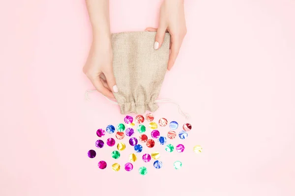 Hermosas manos femeninas corbata lazo festivo en la caja de regalo presente en el fondo de confeti rosa. Concepto Navidad, Año Nuevo — Foto de Stock