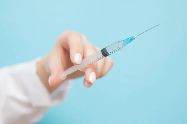 Beauty spa doctor holding syringe on blue background. Female hand with manicure — 스톡 사진