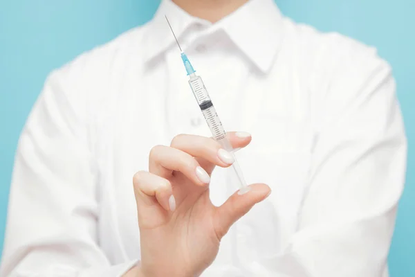 Beauty spa doctor holding syringe on blue background. Female hand with manicure — 스톡 사진