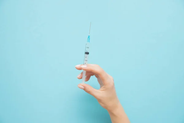 Beauty spa doctor holding syringe on blue background. Female hand with manicure — 스톡 사진