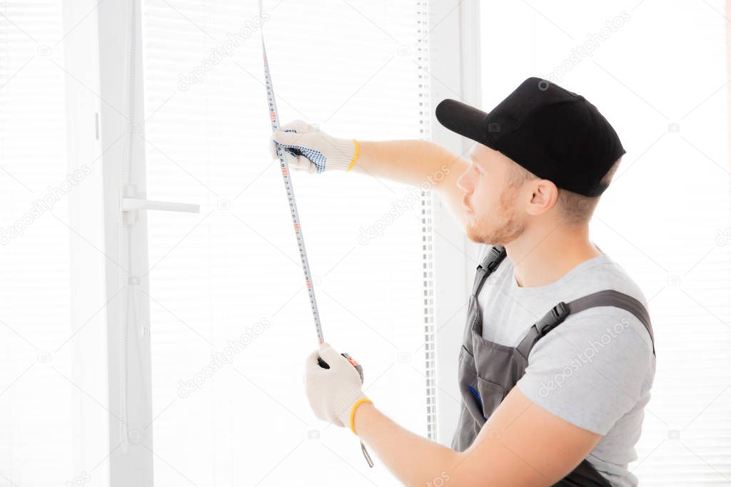 Master worker measures upvc window with ruler, installation process