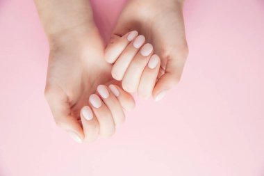 Pembe arka planda jöle cilalı güzel kadın elleri, üst manzara.