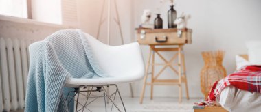 Beyaz sandalyeli, İskandinav tarzı bir yatak odası.