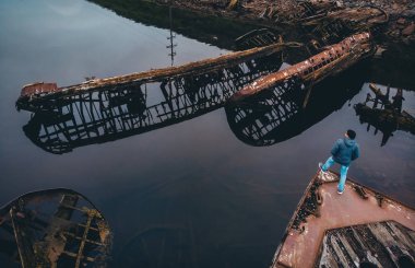 Turist, eski ahşap gemiler Teriberka, Murmansk bölgesi, Rusya 'nın mezarlığına bakıyor. Havadan üst görünüm