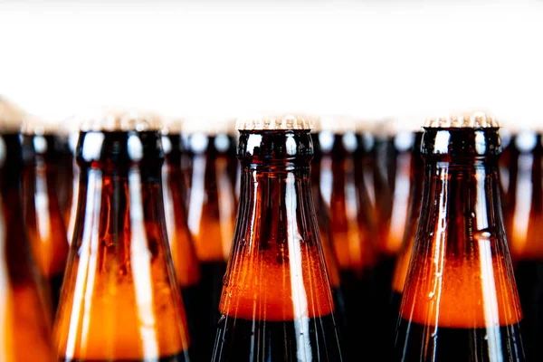 Коричневое стеклянное пиво пьют спиртные бутылки, пивоваренный конвейер, производственная линия — стоковое фото